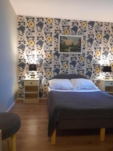 a bedroom with a bed and two tables and a wall at Noclegi u Marii in Gorzów Wielkopolski