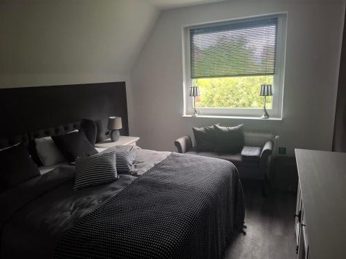 a bedroom with a bed and a window and a chair at Himmelhoog in Emden