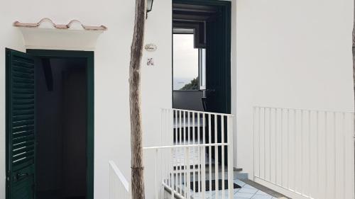 a white house with a green door and a staircase at Al Poggio Antico in Amalfi
