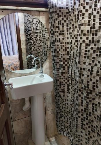 a bathroom with a sink and a shower curtain at Terra da Luz - Casa de praia CE in Cascavel