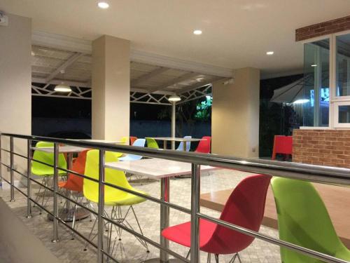 a balcony with a table and colorful chairs at The Garden Living in Bangkok