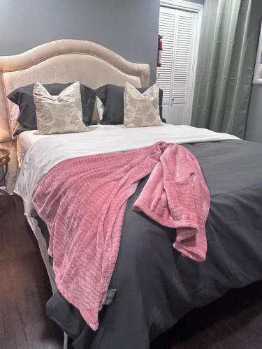 a bed with a pink blanket on top of it at My lil doll house in Elizabeth