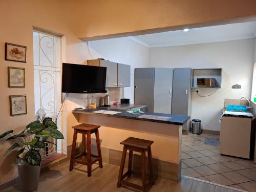 a kitchen with a counter and stools in a room at Carpe Diem in Brakpan