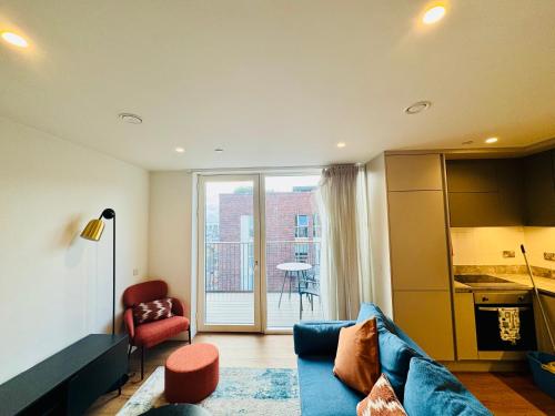 un salon avec un canapé bleu et une cuisine dans l'établissement Skyline Serenity Dublin, à Dublin