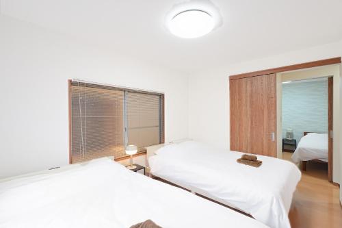 duas camas num quarto de hospital com uma janela em Monthly Only Kotori Akasaka Ideal Place for Long-term Stay and Workcation em Tóquio