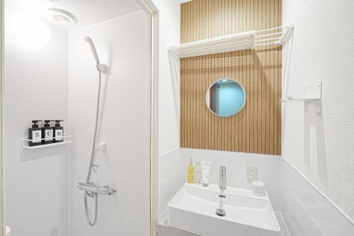um banheiro branco com pia e chuveiro em Monthly Only Kotori Akasaka Ideal Place for Long-term Stay and Workcation em Tóquio