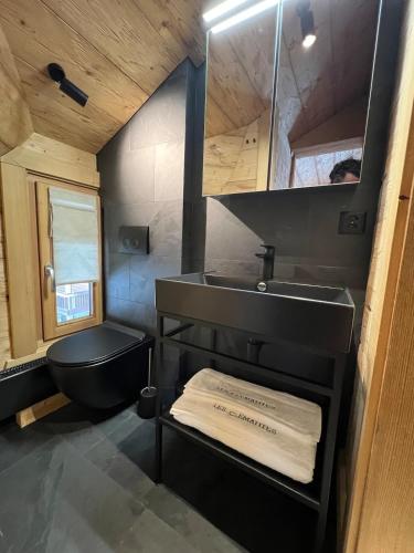 a bathroom with a black toilet and a sink at -Les Clématites- Chalet Exclusif, Villars Centre in Villars-sur-Ollon