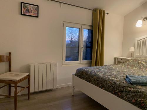 un dormitorio con una cama y una ventana en L'Hortensia, en Beuvron-en-Auge