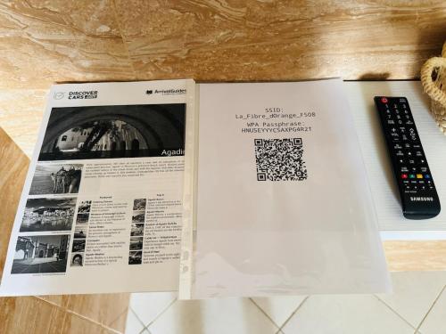 a book and a remote control sitting on a counter at Cozy & Chic Agadir Netflix, Beach & Comfort in Agadir