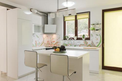 een keuken met een witte tafel en stoelen bij Villa Petra in Kastav
