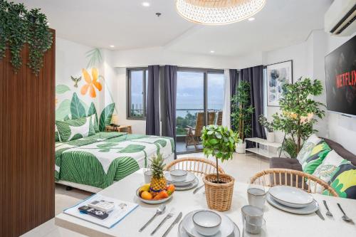 a living room with a dining table and a bedroom at Jungle Studio at Tambuli Ocean View by Dominik Studio with Pool & Balcony in Mactan in Lapu Lapu City