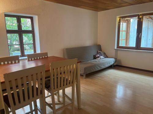 a dining room with a table and a cat laying on a couch at Fachwerkzauber Eggenbach in Ebensfeld