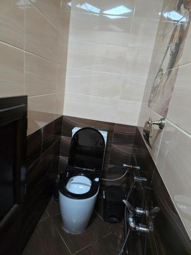 a bathroom with a white toilet with a black seat at Paradise Otel 