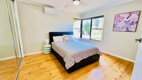 a bedroom with a bed and a window at Lakeside Haven - Park the Boat, Relax and Unwind in Mulwala