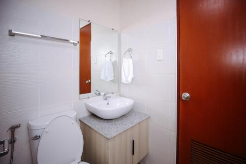 a white bathroom with a sink and a toilet at The Studio Haven in Bacolod