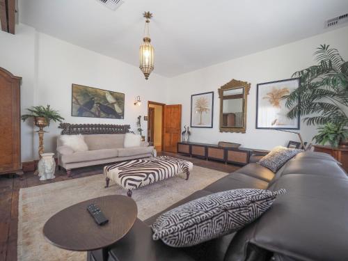 a living room with a leather couch and a zebra print ottoman at Norfolk House Fremantle in Fremantle