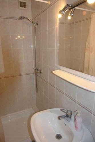 a bathroom with a sink and a shower with a mirror at Mecsek üdülő ingyenes klímával 300 m-re a fürdőtől in Harkány