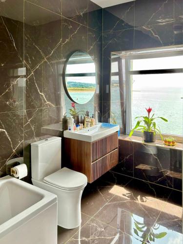 a bathroom with a toilet and a sink and a mirror at York House in Exmouth