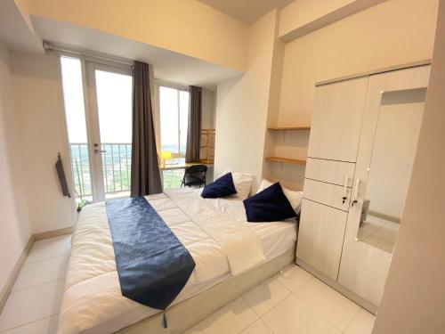 a bedroom with a large bed with a large window at Tokyo River side PIK2 By Micky Studio 7 in Muara