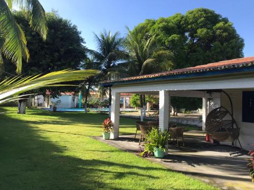 a porch of a house with chairs and a yard at Sitio Damiana in Paracuru