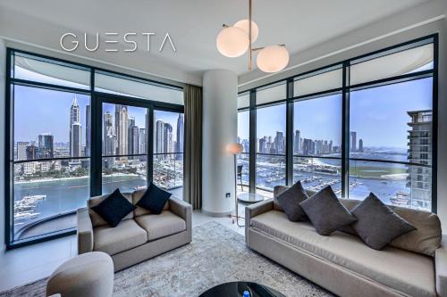 a living room with two couches and large windows at Emaar Beachfront - Marina Vista Tower, Dubai Marina in Dubai