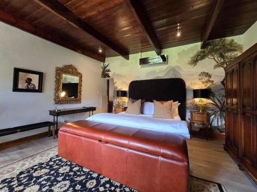 a large bedroom with a red bed and a piano at Webersburg in Stellenbosch