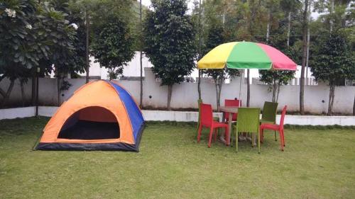 une tente et des chaises et une table sous un parasol dans l'établissement Hotel O SANVI RESORT, à Pune