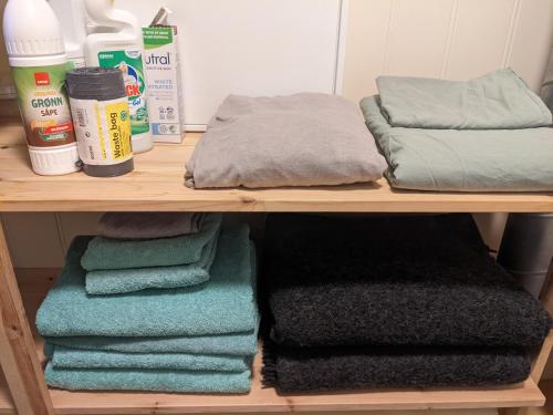 ein Regal mit Handtüchern und anderen Gegenständen darauf in der Unterkunft Apartment, Sea View, Terrace, Free Parking in Tromsø