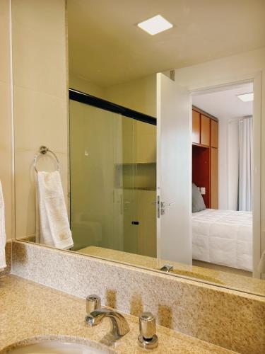 ein Badezimmer mit Waschbecken und großem Spiegel in der Unterkunft Apartamento Serra Bella Itaipava in Araras Petropolis
