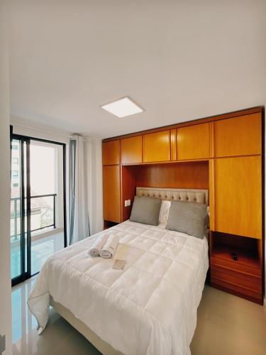 ein Schlafzimmer mit einem großen Bett mit einem hölzernen Kopfteil in der Unterkunft Apartamento Serra Bella Itaipava in Araras Petropolis