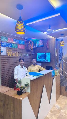 two men sitting at a counter in a restaurant at Hotel Wellingten in Mumbai
