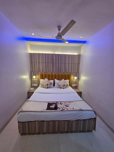a bedroom with a large bed with a blue ceiling at Hotel Wellingten in Mumbai