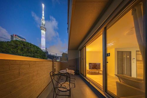 a balcony with a table and chairs and the television tower at Skytree House Oshiage New 3-story Villa, 2 Showers, 2 Toilets, 4 Rooms, 3 min walk to Oshiage Station in Tokyo