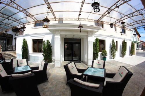 a group of chairs and tables in front of a building at Hotel Rais in Târgu Jiu