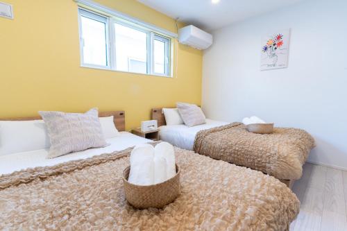 two beds in a room with yellow walls and windows at Grandioso Onna 7-D - Vacation STAY 13349v in Atsutabaru