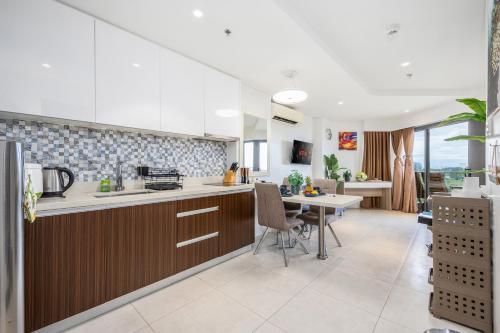 a kitchen with a table and a dining room at Dominiks Comfort and silent Studio Tambuli Balcony Pool Mactan Ocean View High Floor in Lapu Lapu City