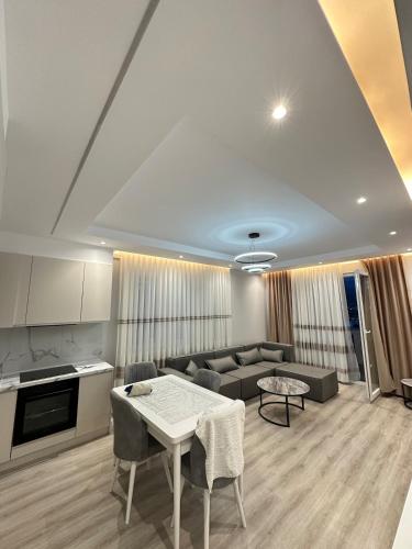 a living room with a couch and a table at Apartment in Kamëz