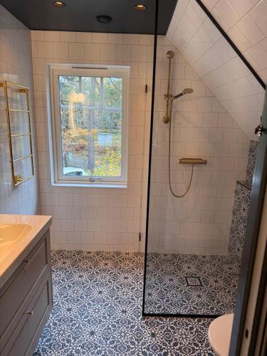 a bathroom with a shower and a sink and a window at Pilvägen 7 in Skå