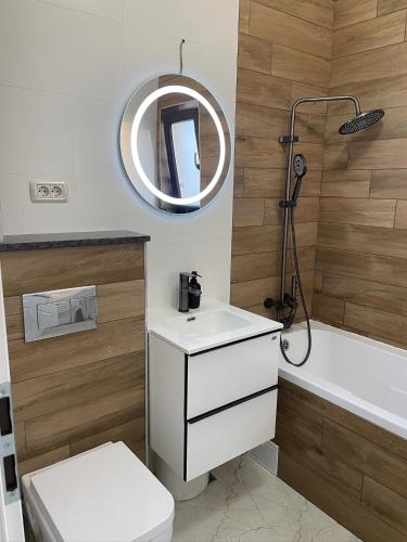 a bathroom with a toilet and a sink and a mirror at Apartament Vedere relaxantă in Ipoteşti