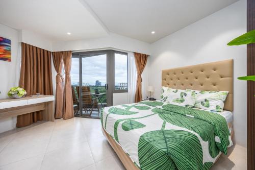 a bedroom with a large bed and a balcony at Dominiks Comfort and silent Studio Tambuli Balcony Pool Mactan Ocean View High Floor in Lapu Lapu City