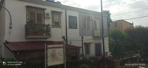 un bâtiment blanc avec des fenêtres et une clôture dans l'établissement Appartamento Bisa Queen, à Bisacquino