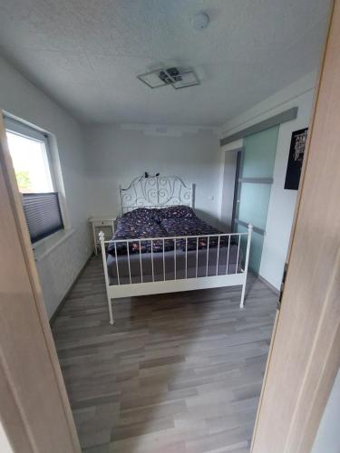 a bedroom with a white bed in a room at Schöne Wohnung direkt am Bach in Neunkirchen am Sand