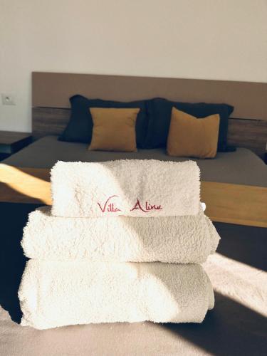 a pile of towels sitting on top of a bed at Villa Aline Lagune Djerba in Midoun