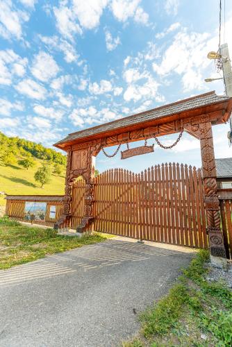 a wooden fence in front of a wooden building at Pensiunea Suci in Botiza