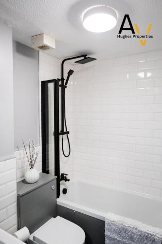 a bathroom with a toilet and a bath tub at Northampton Pop Art House - Free Parking - Fast Wi Fi by AV Hughes Properties in Northampton