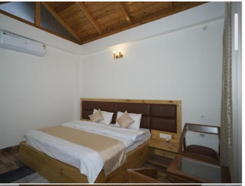 un dormitorio con una cama y una silla en Aesquire Hotel, en Bhimtal