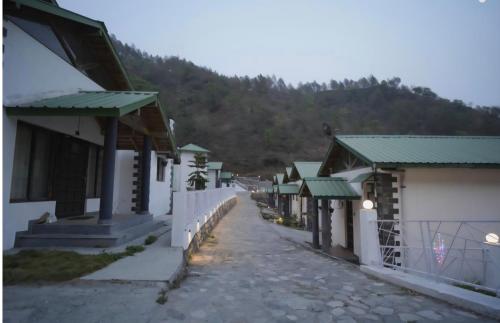 una calle de edificios con una montaña al fondo en Aesquire Hotel, en Bhimtal