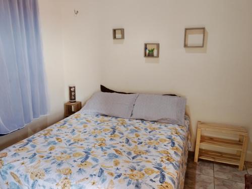 カスカベウにあるTerra da Luz - Casa de praia CEのベッドルーム1室(花柄の掛け布団付きのベッド1台付)