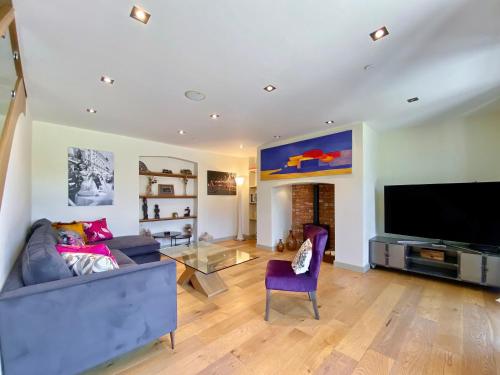 a living room with a couch and a flat screen tv at Wellesley House in Wells
