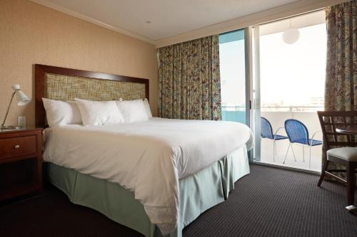 a hotel room with a bed and a balcony at Pan American Oceanfront Hotel in Wildwood Crest